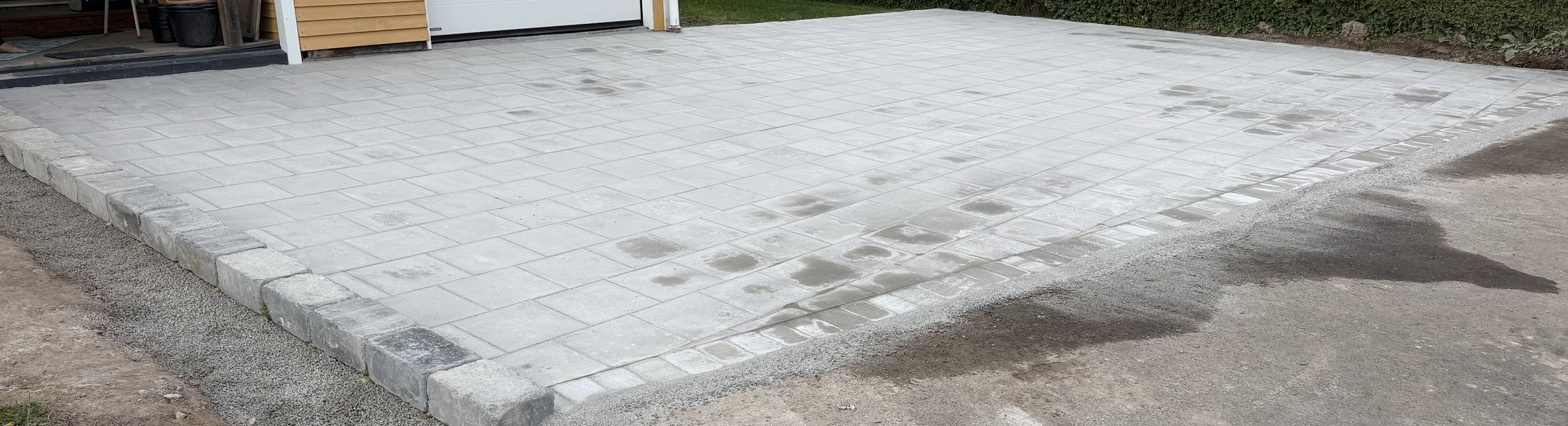 Stor garageuppfart med ljus marksten